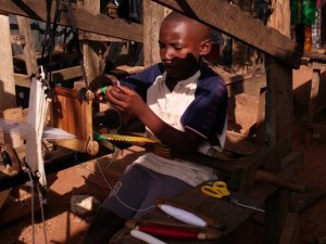 Boy weaving kinta cloth